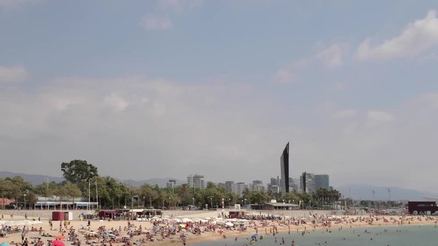 a busy beach in the Port Olympic area of Barcelona
