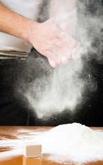 Male baker shaking out flour from his hands