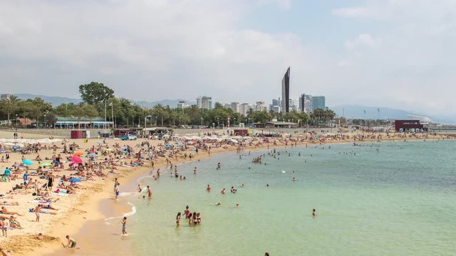 timelapse of a busy beach in the Port Olympic area of Barcelona