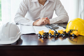 Hands of Engineer working on blueprint,Construction concept.