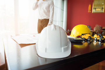 white, yellow and blue hard safety helmet hat for safety project of workman as engineer or worker on desk