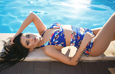 Beautiful girl in a sexy bikini near pool