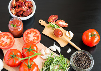 Ingredients. Fresh tomatoes, Sun-dried tomatoes, Tomato Sauce and Spices on dark background. Cooking concept. Healthy foods.