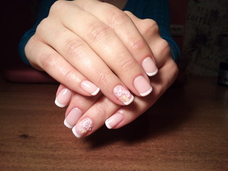 The manicurist excellently made her work a beautiful manicure with a polish gel on her hands and the client is happy