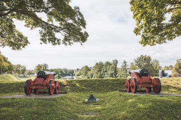 2 cannons and a stack of cannonballs