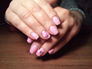 The manicurist excellently made her work a beautiful manicure with a polish gel on her hands and the client is happy