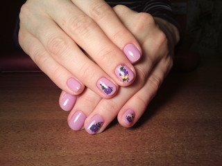 The manicurist excellently made her work a beautiful manicure with a polish gel on her hands and the client is happy