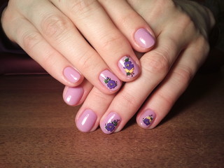 The manicurist excellently made her work a beautiful manicure with a polish gel on her hands and the client is happy