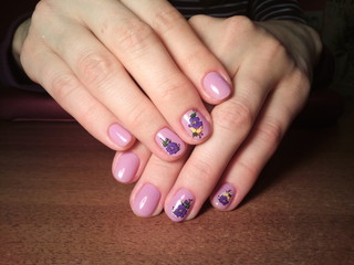 The manicurist excellently made her work a beautiful manicure with a polish gel on her hands and the client is happy