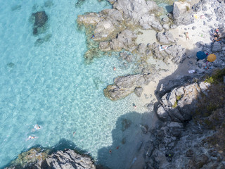 Vista aerea di scogli sul mare. Panoramica del fondo marino visto dall’alto, acqua trasparente. Nuotatori, bagnanti che galleggiano sull’acqua