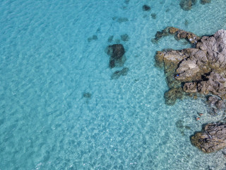 Vista aerea di scogli sul mare. Panoramica del fondo marino visto dall’alto, acqua trasparente. Nuotatori, bagnanti che galleggiano sull’acqua