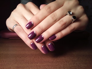 The manicurist excellently made her work a beautiful manicure with a polish gel on her hands and the client is happy