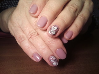 The manicurist excellently made her work a beautiful manicure with a polish gel on her hands and the client is happy