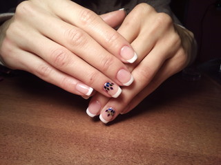 The manicurist excellently made her work a beautiful manicure with a polish gel on her hands and the client is happy