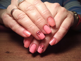The manicurist excellently made her work a beautiful manicure with a polish gel on her hands and the client is happy