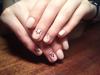 The manicurist excellently made her work a beautiful manicure with a polish gel on her hands and the client is happy