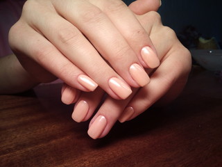 Naklejka premium The manicurist excellently made her work a beautiful manicure with a polish gel on her hands and the client is happy