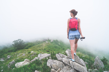 Naklejka na ściany i meble girl traveler with a camera in mountains