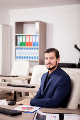 Portrait of Businessman in suit working in his office. Business and corporate. Image of young succesful entrepreneur at his work place.