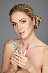 beautiful girl holding syringes