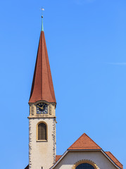 Fototapeta na wymiar Clock tower of the protestant church in the town of Wallisellen in the Swiss canton of Zurich