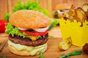 Delicious handmade burger on wooden background. Close view