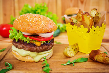 Delicious handmade burger on wooden background. Close view