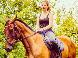 Young woman ridding on a horse