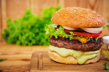 Delicious handmade burger on wooden background. Close view