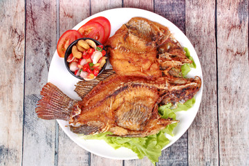Deep fried Tilapia with spicy and sour herb salad .