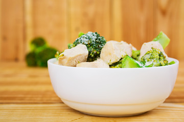 Chicken with broccoli on a wooden background