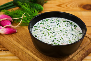 Cold soup okroshka on wooden background