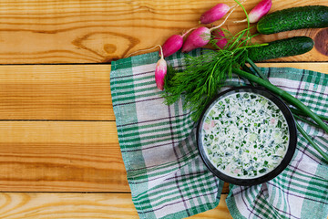 Cold soup okroshka on wooden background