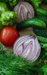 Beautiful green greens with cucumbers and red tomato and onions.