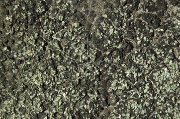 a lot of green pebbles in black resin