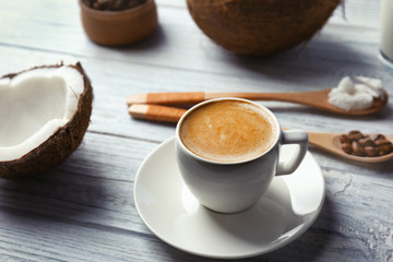 Cup with drink and ingredients for coconut coffee on wooden table