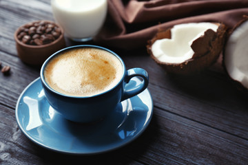 Cup with drink and ingredients for coconut coffee on wooden table