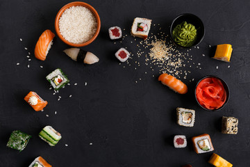 Fototapeta na wymiar Sushi and rolls background, frame on black, top view.
