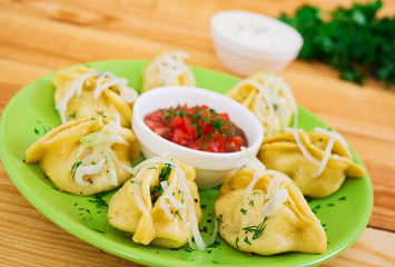 Delicious manti dumplings on wooden background