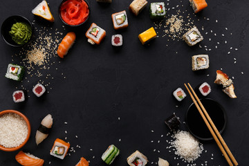 Sushi and rolls background, frame on black, top view. © Prostock-studio