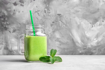 Mason jar of fresh juice on grunge background