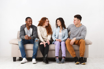Happy young friends, casual people sitting on couch