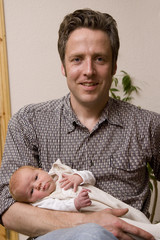 Glücklicher Vater mit seinem neugeborenen Baby auf dem Arm