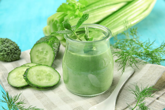 Jar of fresh vegetable juice on color background