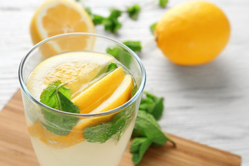 Glass of fresh lemonade on wooden background