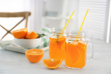 Mason jars of fresh orange lemonade on table