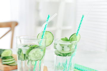 Glasses of fresh cucumber lemonade on table