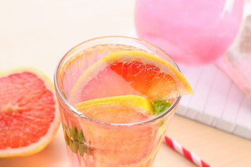 Glass of fresh grapefruit lemonade on wooden background