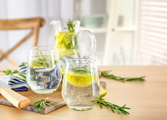 Glasses of fresh lemonade with rosemary on table