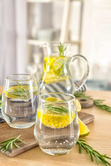 Glasses of fresh lemonade with rosemary on table